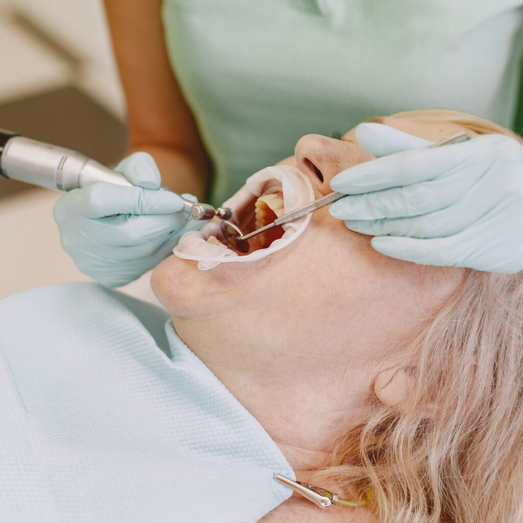 Dentist doing scaling and gum cleaning for a patient
